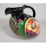 An unusual Moorcroft ewer with fig, grape and berry design on a dark blue ground and with