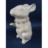 An unusual cream glazed model of a seated rabbit, possibly oriental, with floral moulded collar,