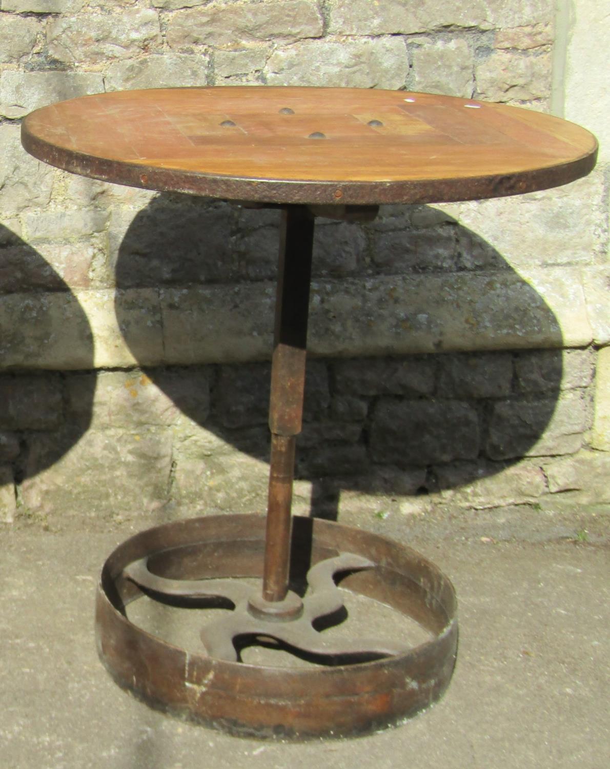 An industrial style steam punk bistro table, the circular pine segmented top with iron rim, raised