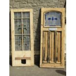 A reclaimed partially stripped hardwood front door, enclosing an arched leaded light panel and three
