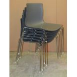 A set of six contemporary stacking dining chairs with moulded seats and polished chrome supports,