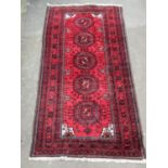 Good Afghan Balouchi type runner/rug with five medallion centre upon a red ground, 255 x 135 cm