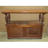 A 1920s narrow oak monks/hall bench, the rectangular sliding top raised on baluster supports over