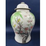 An oriental vase and cover of shouldered form with polychrome painted tree with blossom and with