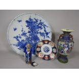 A large oriental blue and white charger with flowering plant, prunus blossom and woven fence