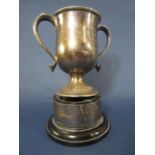 A silver agricultural stock judging trophy with loop handles on a raised plinth, London 1910, 12.5oz