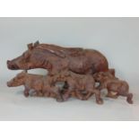 A carved continental hardwood group showing a wild boar and its three young, 60cm long