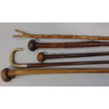 A Victorian walking stick with silver cuff and horn handle, three African hardwood club and a