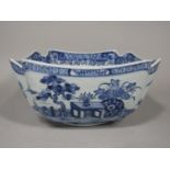 A 19th century oriental bowl of four sided form with blue and white painted landscape and building