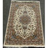 A fine woven full pile Persian rug with scrolled foliate and floral medallion design upon an ivory