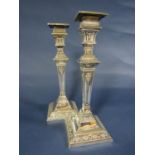 Pair of silver candlesticks of classical design and square cut brass repeating husk, ribbon and
