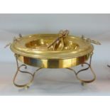 A 19th century brass brazier of circular form with axe head shaped handles raised on a European