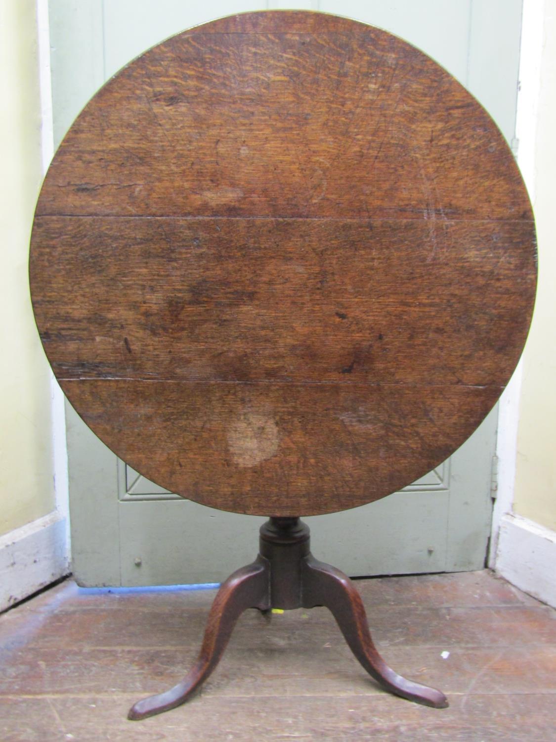 A Georgian oak snap top table on turned pillar and tripod, 83cm diameter