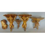 A pair of 19th century carved and gilded wall brackets in the form of cherubs supporting scallop