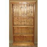 A rustic reclaimed pine freestanding open bookcase with fixed shelves and tongue and groove
