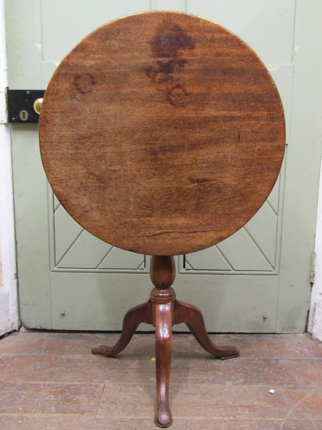 A Georgian mahogany snap top table, the single piece 64cm diameter top rasied on a vase shaped