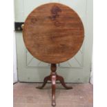 A Georgian mahogany snap top table, the single piece 64cm diameter top rasied on a vase shaped