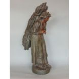 A 19th century French spelter figure of an old woman carrying a bundle of timber, 53cm high