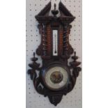 Aneroid barometer win a carved softwood frame with spiral twist, acanthus and turned finial detail