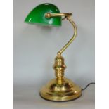 A brass bankers lamp with green glass shade