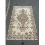 Unusual Turkish Yuruk rug with central floral medallion in pale colours upon a cream ground, 300x