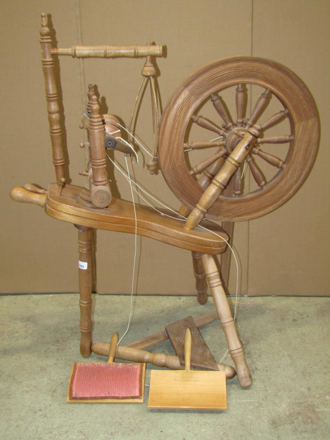 A traditional spinning wheel in beech with turned spindles, stamped underneath G W Cummeber, Watleys