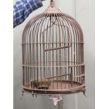 A brass bird cage of circular form with domed canopy, raised on shaped and pierced supports, 50cm