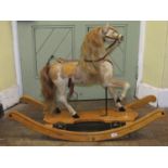 A 19th century child's rocking horse, the prancing horse with canvas and leather saddle, stirrups