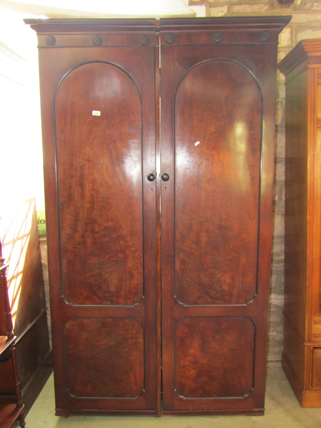 Two 19th century mahogany sentry box wardrobe sections enclosed by full length arched panelled doors