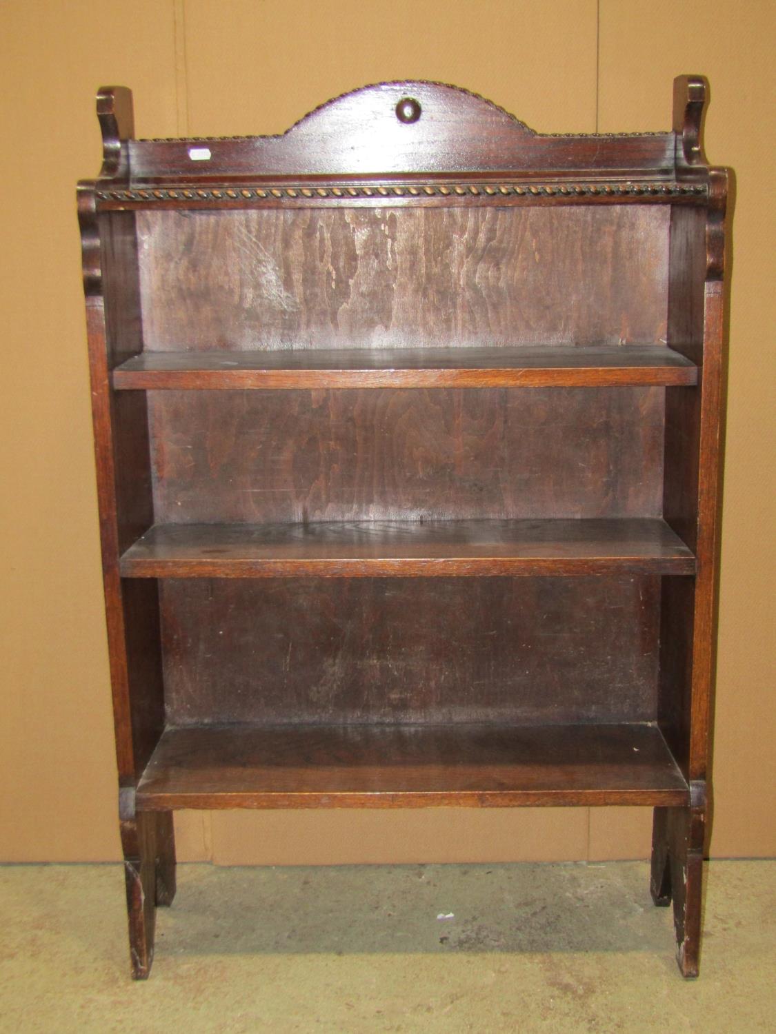 A 1920s oak freestanding open bookcase with fixed shelves, the upper with bow front and appllied