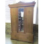 An Edwardian stripped walnut sectional wardrobe enclosed by three three-quarter length panelled