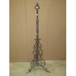 An Art Nouveau/craft style ironwork telescopic oil lamp standard with tubular stem, flanked by
