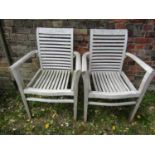 A pair of bleached teakwood elbow chairs with ladderbacks
