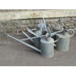 A selection of vintage galvanised watering cans, one marked 'Haws'