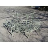 A decorative metal tree seat of semi circular design with repeating detail, 180 cm diameter (to