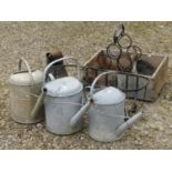 A collection of galvanised iron including three watering cans, further conical shaped pot, wine rack