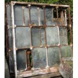 A set of three reclaimed Victorian industrial cast iron window frames each enclosing twelve panes,