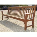 A large good quality teak park bench with slatted seat and back, 255 cm long