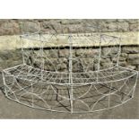 A Victorian ironwork demi-lune two tier plantstand with repeating decorative finish, 125 cm in