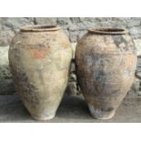 A matched pair of old terracotta storage jars of inverted tapering form with simple incised