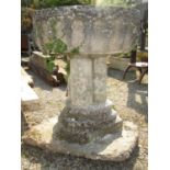 A reclaimed D end font raised on a trefoil column stand in an early ecclesiastical style together