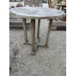 A wooden patio table of circular form, 75cm diameter approx