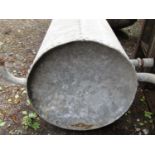 A galvanised iron water cylinder with riveted panels, 90 cm in length x 50 cm diameter