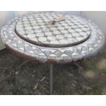 A garden fire pit of circular form with mosaic border and cover, raised on three scrolled