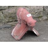A ridge tile with terracotta colourway in the form of a cat peering down