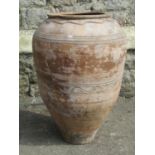 A terracotta oviform storage jar with simple incised detail, 60 cm