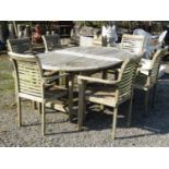 A weathered teakwood garden table, 178cm long x 120cm wide, together with six weathered teak elbow