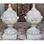 A pair of reclaimed garden finials globular with acanthus leaf detail raised on square cut bases, 55