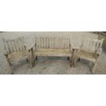 Three piece teakwood garden set comprising a two seat bench and two matching armchairs, the bench