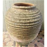 A substantial terracotta coiled olive storage jar, 80 cm in height